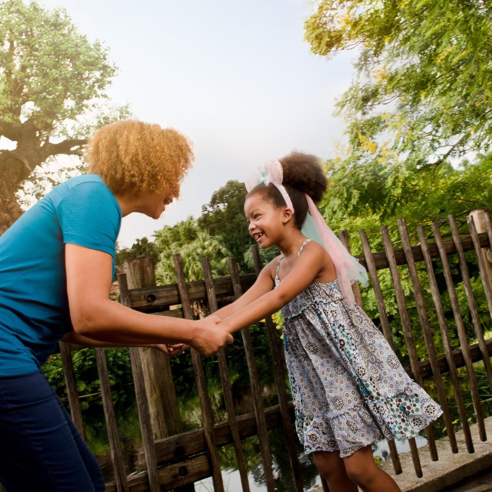 Mother and daughter holding hands outside