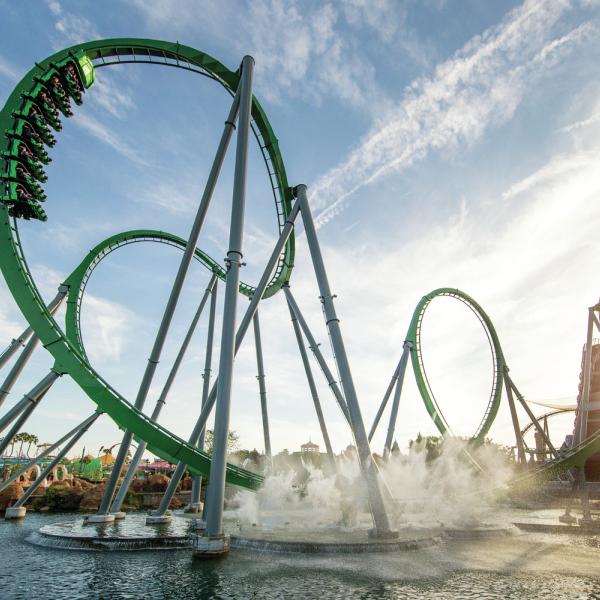 The Incredible Hulk Coaster at Universal’s Islands of Adventure launches riders through high-speed loops above the water under a bright Florida sky.