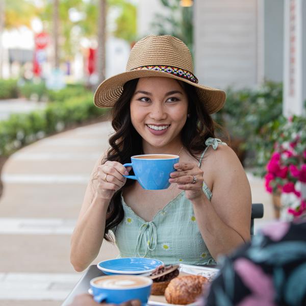woman sipping cup of coffee at table
