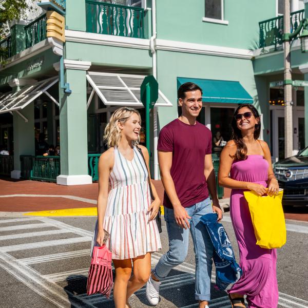 friends walking down crosswalk on Market street in downtown celebration carrying shopping bags