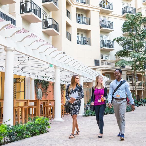 Three meeting attendees walking in the Gaylord Palms Convention Center
