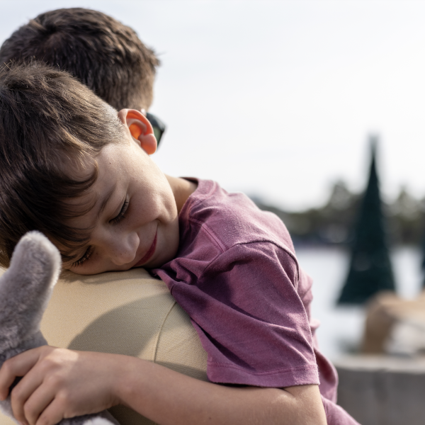 Dad holds young, sleeping son at SeaWorld Orlando.