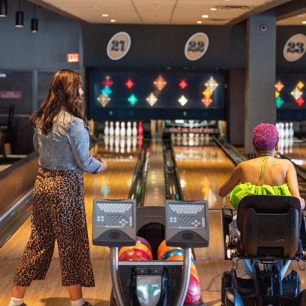 Lolo Spencer bowls in a motorized wheelchair with Jen Bonner at Splitsville
