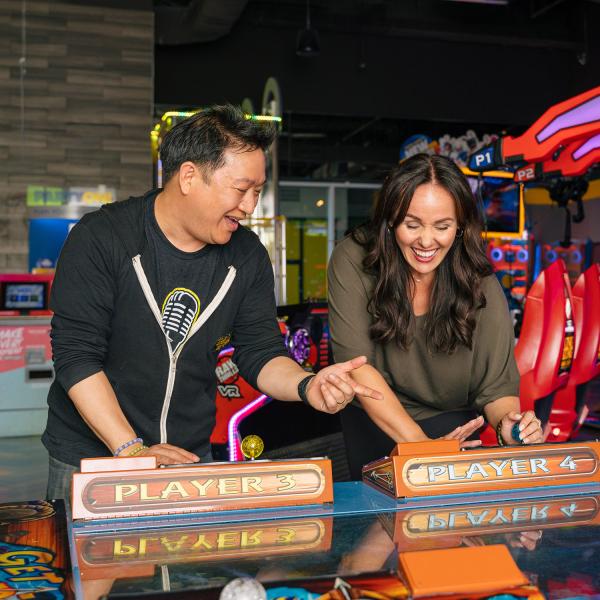 Ming Chen and Jen Bonner play an arcade game at Main Event Entertainment.