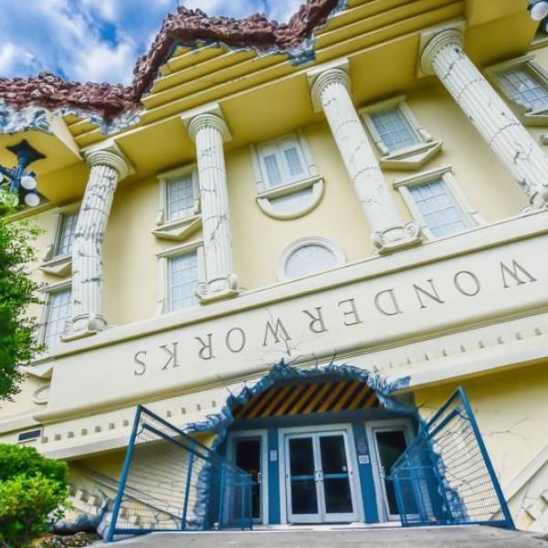 Exterior of WonderWorks Orlando, designed to look like an upside-down building with columns and a tilted entrance.