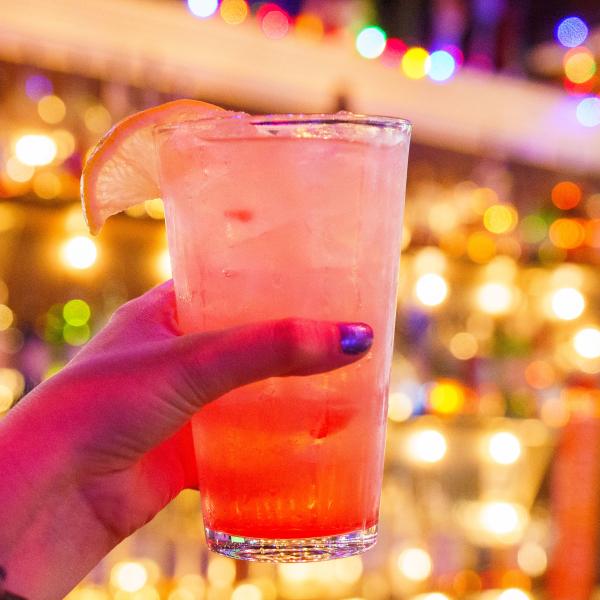 A glass of Kissimmee Lemonade from local bar Breeze Kissimmee, featuring a citrus garnish against a lively bar backdrop.