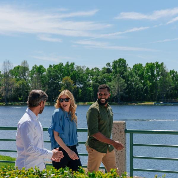 Two men and a woman walk the water front in Celebration.