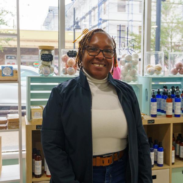 Sherida “Hunnie” Emans, owner of Hunnies Body Butter in downtown St. Cloud, Florida, standing proudly by a display of natural soaps, bath bombs and liquid body butters.