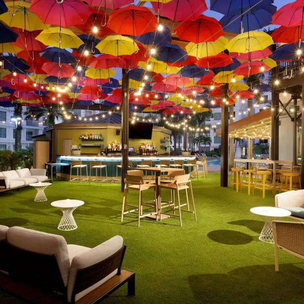 The Wilson offers indoor and outdoor seating. Outdoor seating is under a covered patio with warm string lights, decorative umbrellas, cozy benches and chairs.