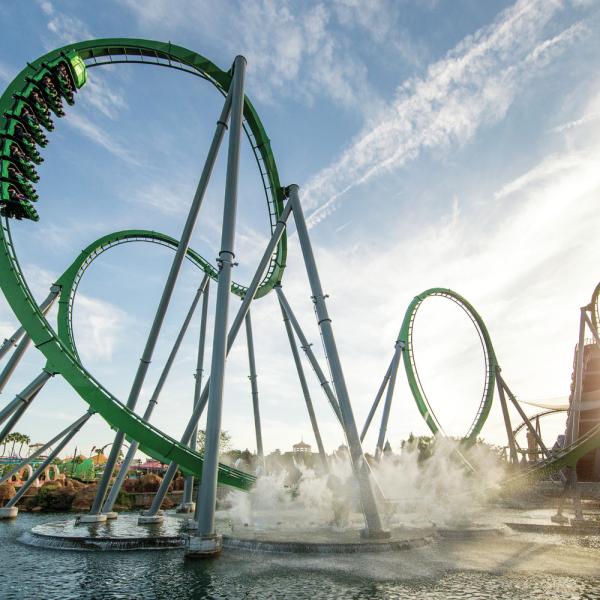 The Incredible Hulk Coaster at Universal’s Islands of Adventure launches riders through high-speed loops above the water under a bright Florida sky.