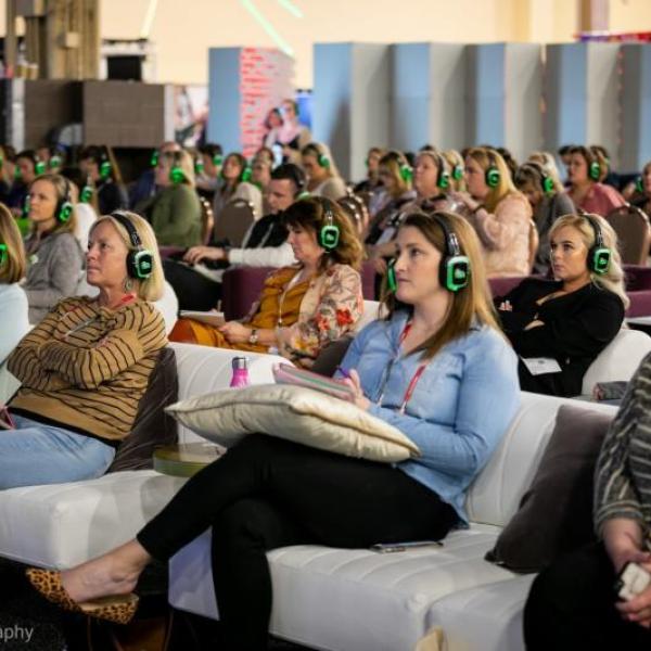 Attendees wearing wireless headsets participate in a silent conference session in Kissimmee, Florida, during an interactive meeting designed to inspire creativity and engagement in a relaxed lounge-style setting.