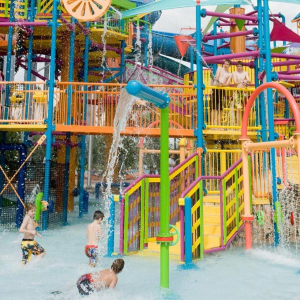 Children playing under water sprays and colorful structures at Aquatica, SeaWorld’s Waterpark in Orlando, Florida.