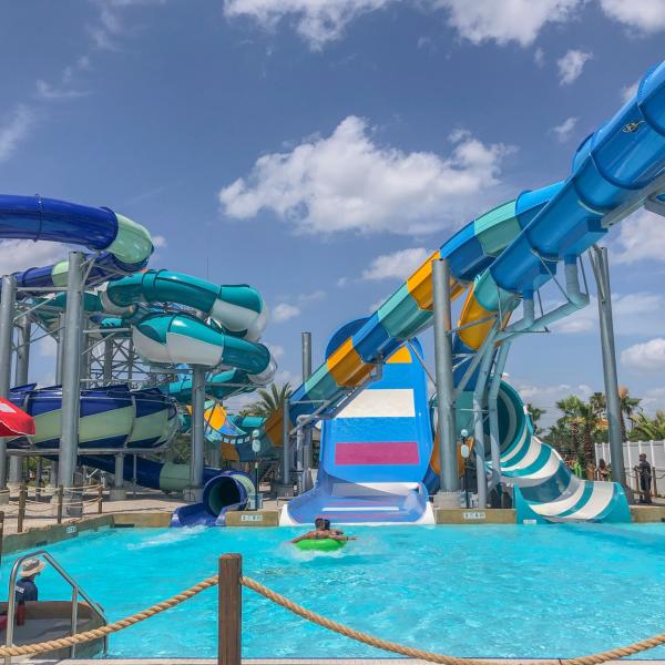 Colorful water slides at Island H2O Water Park in Kissimmee, Florida, with guests enjoying a sunny day and lifeguards stationed nearby.