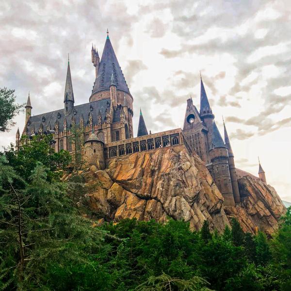 View of the Hogwarts Castle attraction perched on a rocky hillside at Universal’s Islands of Adventure in Orlando, Florida.