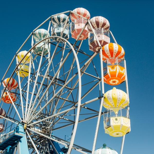 multi-colored ferris wheel cages against a blut sky