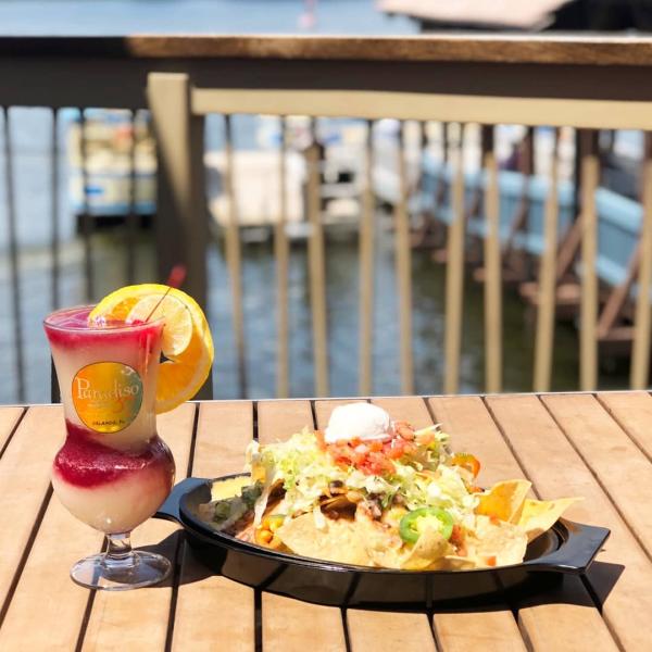 Cocktail and plate of nachos on an outdoor table at Paradiso 37 in Disney Springs