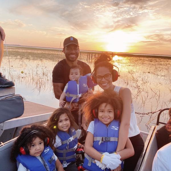 Dr. Laura and her family on an airboat at golden hour