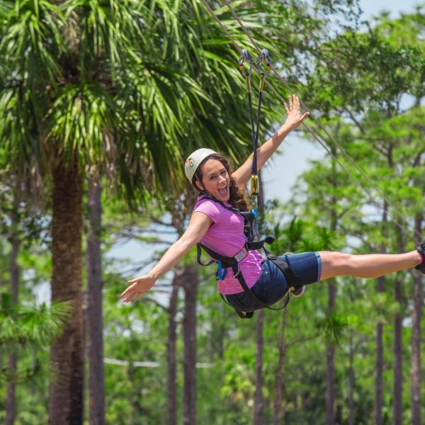 A woman ziplining through the treetops