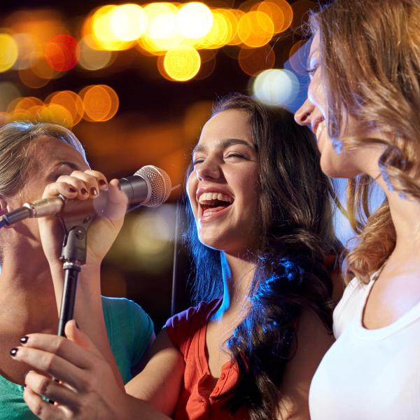 three girls singing karaoke
