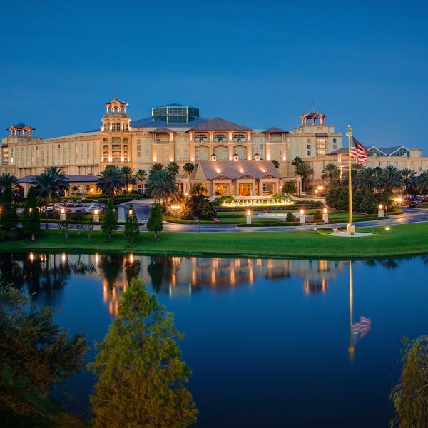 Evening photo of Gaylord Palms Hotels with water in front.
