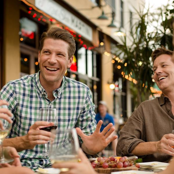 Group of people sitting, laughing and eating.