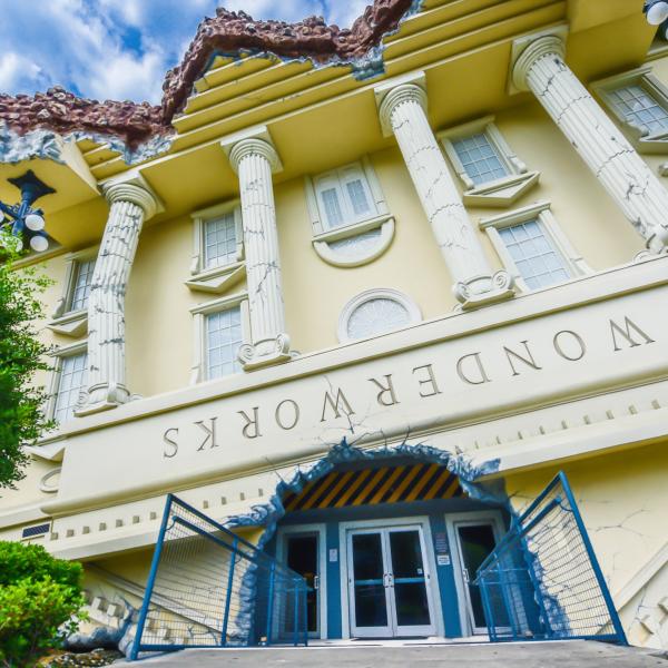 Exterior of WonderWorks Orlando, designed to look like an upside-down building with columns and a tilted entrance.